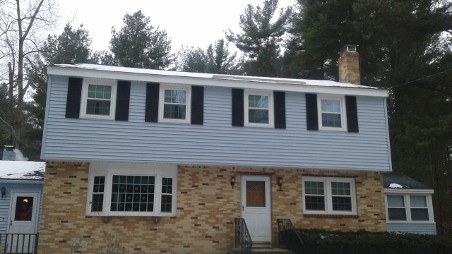 Two-story house with a brick lower and blue upper exterior.