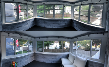 Enclosed porch with large windows, string lights, and wood paneling.